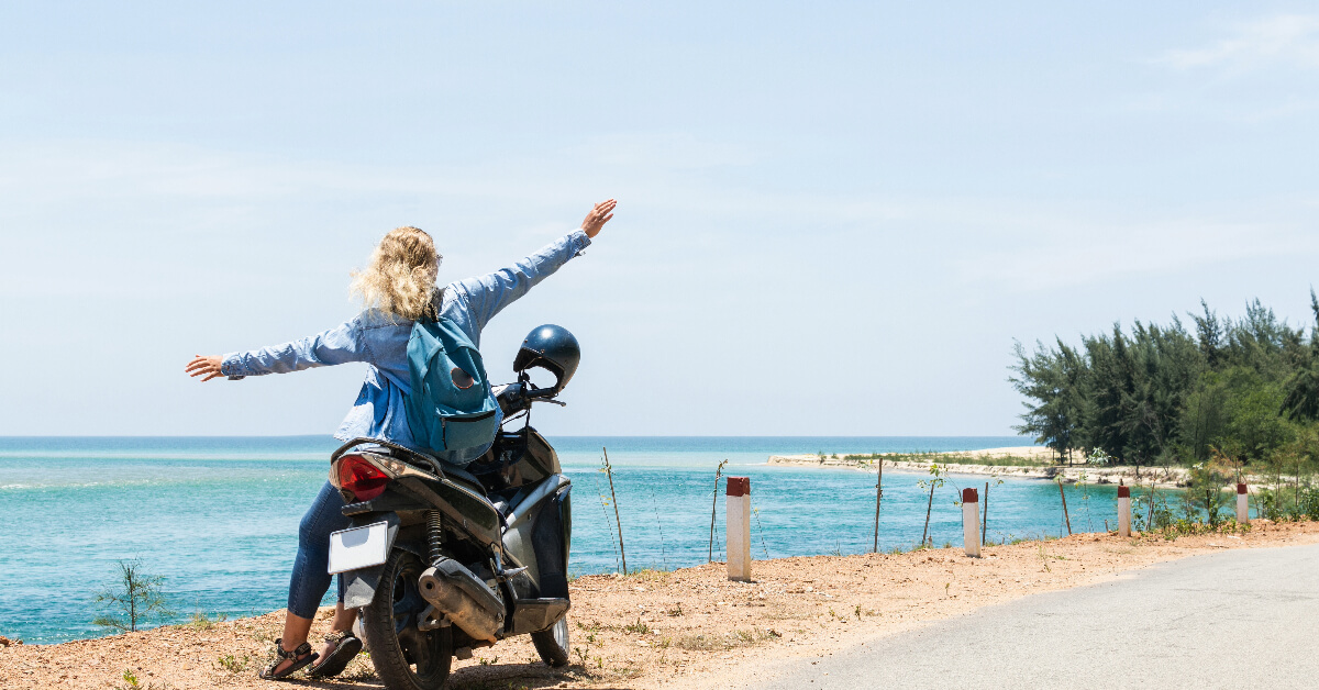 woman on motorcycle stopping by side of road