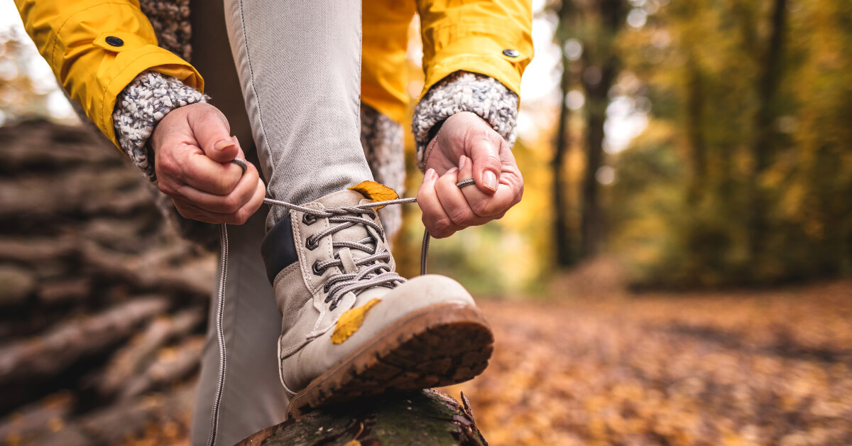 lacing up hiking boots in the woods