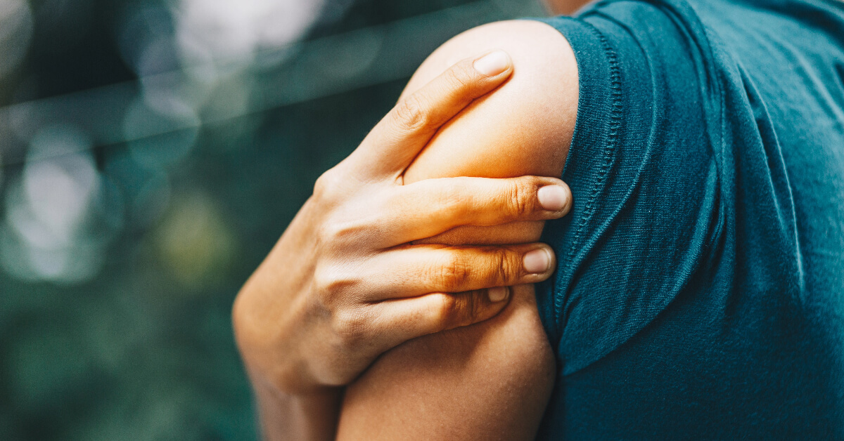 woman rubbing her sore shoulder