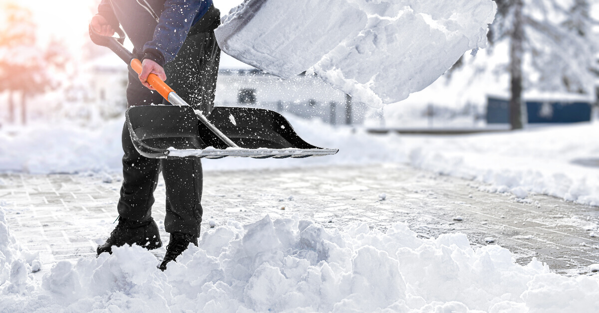 man shovelling snow in his driveway